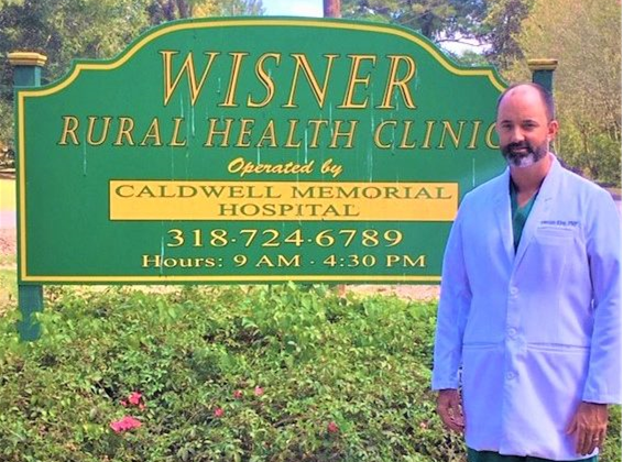 Jeremiah King , FNP standing in front of sign at Wisner Rural Health Clinic in Wisner Louisiana.